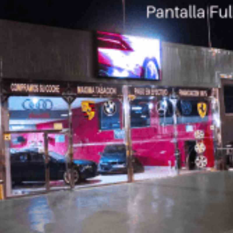 Pantalla LED exterior de alto brillo instalada sobre la fachada de un concesionario de coches en España.
