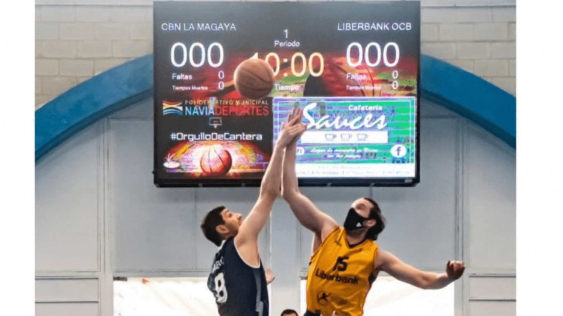 Dos jugadores de baloncesto realizando un salto inicial en una cancha cubierta, con un gran videomarcador LED COSMI de fondo mostrando las puntuaciones del partido.