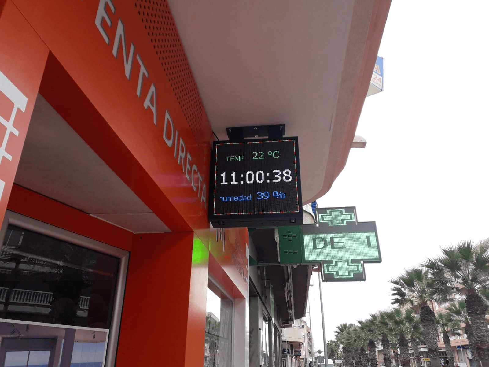Pantalla LED informativa con hora y temperatura en el exterior de un comercio.