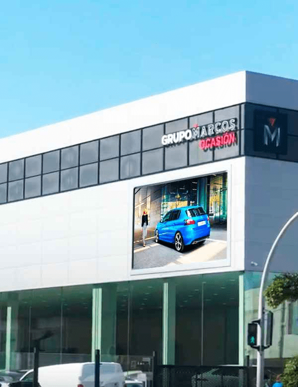 Pantalla LED gigante de publicidad exterior en la fachada de un concesionario.